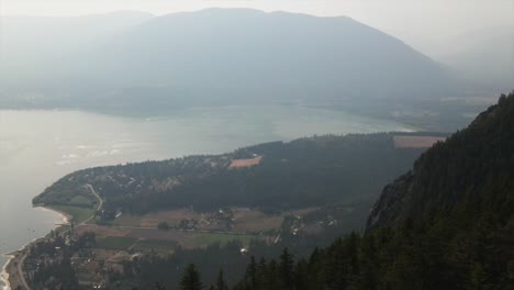 Schöne-Luftaufnahme-Eines-Nebligen-Sees,-Umgeben-Von-Hügeln-Und-Wald