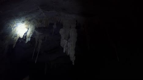 Handheld-shot-of-a-flashlight-lighting-up-various-large-cave-stalactites-inside-the-famous-Lapa-Doce-cave-in-the-Chapada-Diamantina-National-Park-in-Bahia,-northeastern-Brazil