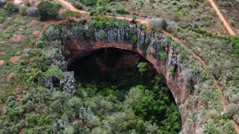 Rotierende-Luftdrohnenaufnahme-Des-Großen-Lapa-Doce-Höhleneingangs-Aus-Bunten-Felsen-Mit-Einem-In-Sich-Geschlossenen-Regenwald-Darunter-Im-Chapada-Diamantina-Nationalpark-In-Bahia-Im-Nordosten-Brasiliens