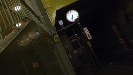 Handheld-surreal-dolly-backward-rotating-shot-of-a-clock-in-a-subway-station-with-tire-walls,-creepy-and-disorienting