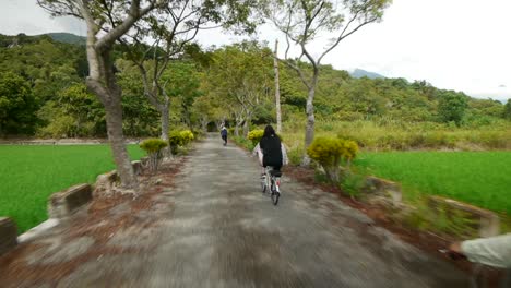 Mujeres-Ciclistas-Recorriendo-Pequeños-Terrenos-Para-Bicicletas-En-El-Campo,-Filmadas-Desde-Atrás-Con-La-Cámara-Pasando-Ciclistas