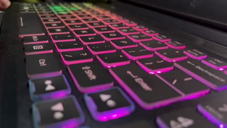Hands-typing-on-laptop-computer-colorful-backlit-keyboard
