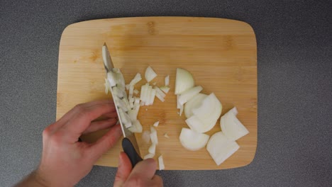 Man-chopping-a-brown-onion-into-small-pieces