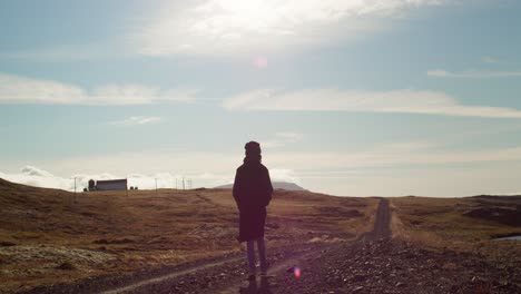 Toma-En-Cámara-Lenta-De-Una-Joven-Caminando-En-Una-Pista-Al-Atardecer-En-Islandia
