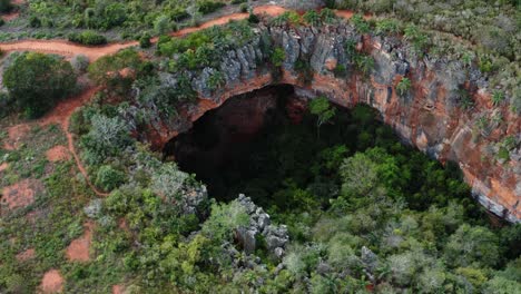 Luftdrohne,-Die-Den-Großen-Lapa-Doce-Höhleneingang-Aus-Bunten-Felsen-Mit-Einem-In-Sich-Geschlossenen-Regenwald-Unten-Im-Chapada-Diamantina-Nationalpark-In-Bahia-Im-Nordosten-Brasiliens-Herunterkippt