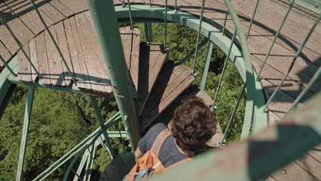 Man-walking-up-a-spiral-starway-on-top-of-a-lookout-tower-on-mountain-Boč