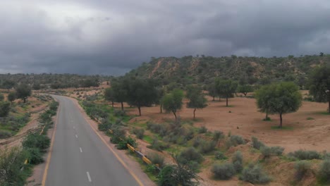 Aerial-Rising-Shot-Over-Remote-Road-Highway-Through-Tharparkar-In-Sindh-With-Overcast-Moody-Clouds