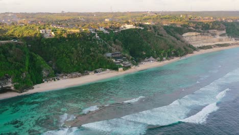 Amplia-Costa-De-Playa-Aérea-De-Uluwatu-Con-Océano-Tropical-En-Bali-Al-Atardecer