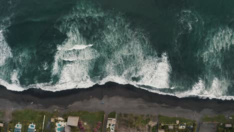 Top-Down-View-Of-Foamy-Ocean-Waves-Splashing-Sandy-Shore-In-El-Paredon,-Guatemala---drone-shot
