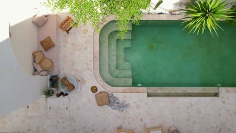 aerial-top-down-of-bohemian-furniture-next-to-tropical-pool-in-a-white-bali-villa