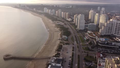 Aerial-view-of-seaside-city,-Punta-del-Este-showing-coastal-road-along-shoreline