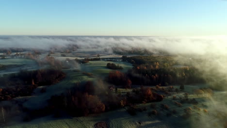 Aerial-cinematic-drone-forward-view-over-rural-landscape-shrouded-in-fog