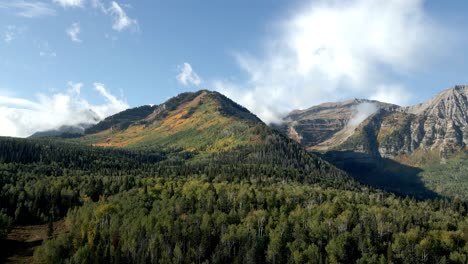 Aufsteigende-Luftaufnahme-Einer-Berglandschaft-Mit-Herbstfarben-An-Den-Hängen