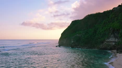 Luftaufnahme-Des-Wunderschönen-Rosafarbenen-Himmels-Bei-Sonnenuntergang-Am-Uluwatu-strand-Auf-Bali