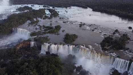 Stunning-aerial-shot-of-gigantic-Iguazu-Waterfalls-between-rocks-during-sunny-day---Brazil-and-Argentina-in-South-America---tourist-spot-with-epic-view-from-drone