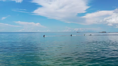 Antenne-Von-Touristen-Auf-Jetskis,-Die-An-Sonnigen-Sommertagen-In-Belitung-Indonesien-Im-Tropischen-Blauen-Wasser-Fahren