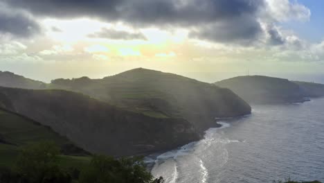 Majestic-sunlit-atlantic-ocean-coastline-with-sunrays-in-Azores,-aerial