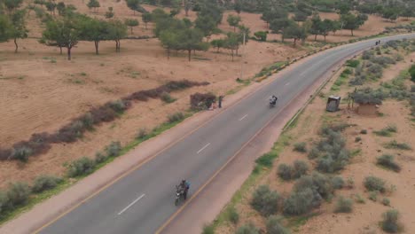 Aerial-Tracking-Shot-Of-Two-Motorbikes-On-Remote-Road-Highway-Through-Tharparkar-In-Sindh