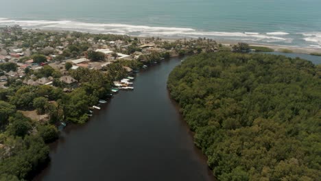 Scenery-Of-River-Surrounded-By-Lush-Tropical-Vegetation-And-Seascape-In-El-Paredon,-Guatemala---aerial-drone-shot