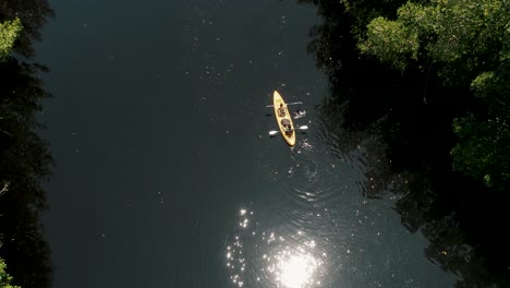 Sonnenlicht-Reflektierte-Sich-Auf-Einem-Ruhigen-Fluss-Mit-Leuten,-Die-In-El-Paredon,-Escuintla,-Guatemala-Kajak-Fahren