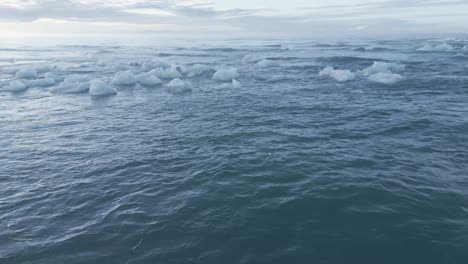 Gebrochenes-Eis,-Das-Auf-Dem-Welligen-Wasser-Des-Meeres-Am-Diamond-Beach-In-Island-Schwimmt