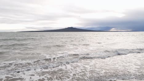 Static-wide-angle-view-from-the-shore-onto-Rangitoto-island-during-a-cloudy-spring-morning