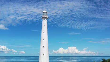 aerial-camera-panning-up-at-white-lighthouse-in-belitung-indonesia-with-beautiful-tropical-blue-water