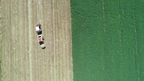 aerial-top-down-Hay-makingTractor-with-making-Hay-Bales-in-an-agricultural-field-Farm-split-in-green-and-yellow-color,-minimalist-agricultural-footage