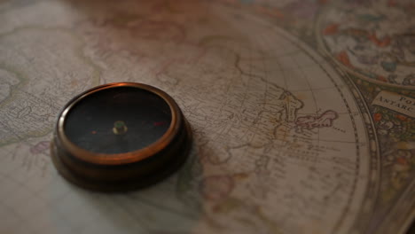 Ein-Antiker-Kompass-Auf-Einer-Vintage-Karte-Bei-Kerzenlicht