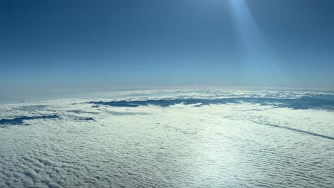 Atemberaubende-Luftaufnahme-Aus-Einem-Jet-Cockpit,-Aus-Sicht-Des-Piloten,-Der-In-12000-Metern-Höhe-Fliegt-Und-Sich-Den-Französisch-italienischen-Alpenbergen-Nähert,-Mit-Sehr-Niedrigen-Wolken-Und-Einem-Herrlichen-Blauen-Himmel-Mit-Sonnenstrahlen
