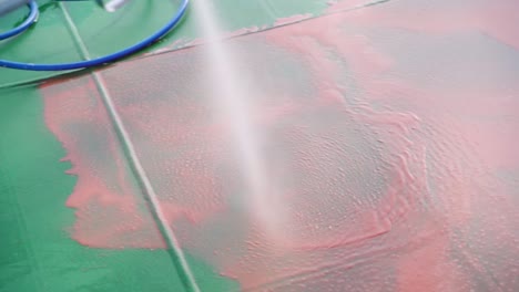 Slow-Motion-Video-4K-Closeup-red-fluid-preparation-high-pressure-ship-deck-floors-from-a-pressure-washer