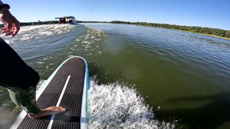 surfer-on-longboard-in-wave-behind-boat