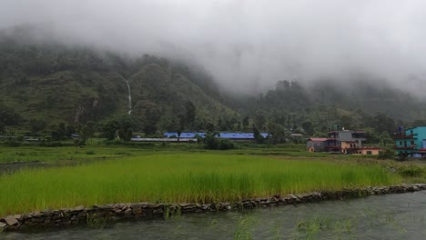 Una-Vista-Panorámica-De-Los-Arrozales-Con-Aguas-De-Inundación-En-Primer-Plano-Y-Montañas-Cubiertas-De-Niebla-En-El-Fondo-Durante-Una-Fuerte-Tormenta-En-Nepal