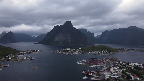 Steep-Norwegian-cliffy-Reinebringen-mountains-and-Reine-fishing-villages-on-islands-surrounded-by-fjords-and-sea-in-Nordland-County-of-Norway---establishing-aerial