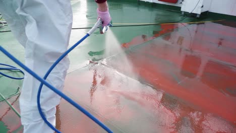 Slow-Motion-4K-Closeup-red-fluid-preparation-high-pressure-ship-deck-floors-from-a-pressure-washer