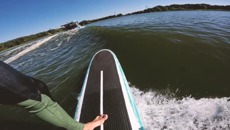 Surfer-Auf-Longboard-In-Welle-Hinter-Boot