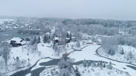 Snow-Covered-Houses-In-Winter-Forest-Background---aerial-drone-shot
