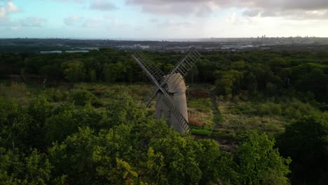 Bidston-Windmill-at-dawn,-aerial-drone-clockwise-pan-sun-kissed-and-beautiful