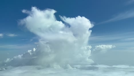 Unique-pilot-point-of-view-taken-from-a-jet-cockpit-flying-toward-a-tiny-fading-cumulus-at-10000m-high