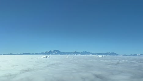 Stunning-aerial-view-from-a-jet-cockpit-departed-from-Milano-airport-flying-northbound-to-cross-the-french-italian-Alps-mpountains-once-crossed-the-clouds-during-climb