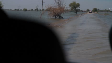 POV-Aus-Dem-Auto-Beim-Navigieren-Auf-Der-überfluteten-Straße-In-Pakistan,-Die-Durch-Wasser-Aus-Dem-See-Verursacht-Wurde