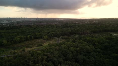 Bidston-Windmill-at-dawn,-aerial-drone-reverse-drone-Liverpool-sunrise-and-storm-clouds