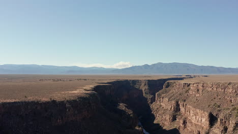Aerial-of-Rio-Grande-gorge-in-with-wildfire-burning-in-distant-mountains
