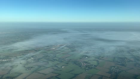 Foggy-lanscape-recorded-from-a-jet-during-the-approach-to-the-airport-of-Nantes,-France,-in-a-autumn-sunny-morning