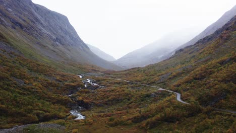 Río-Que-Fluye-Con-Carretera-Rural-En-Las-Montañas-Del-Parque-Nacional-Dovrefjell-sunndalsfjella,-Noruega