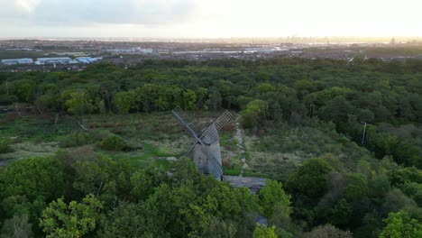 Bidston-Windmill-at-dawn,-aerial-drone-clockwise-inwards-pan-and-Liverpool-sunrise-reveal