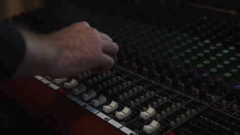 Adjusting-dials-on-a-sound-mixing-board