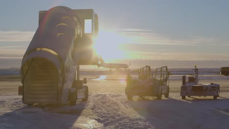 Stair-car-vehicle-standing-on-snow-tarmac-airport-with-bright-sunset-sunlight