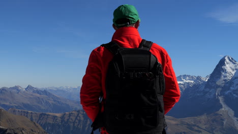 Hombre-Con-Abrigo-Rojo-Admira-Las-Montañas-Jungfraujoch,-Conocidas-Como-La-Cima-De-Europa