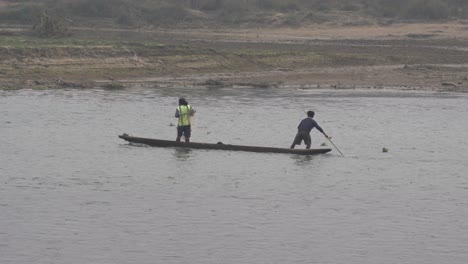 Dos-Hombres-En-Una-Canoa-Pescando-En-Un-Río-En-El-Parque-Nacional-De-Chitwan-En-Nepal